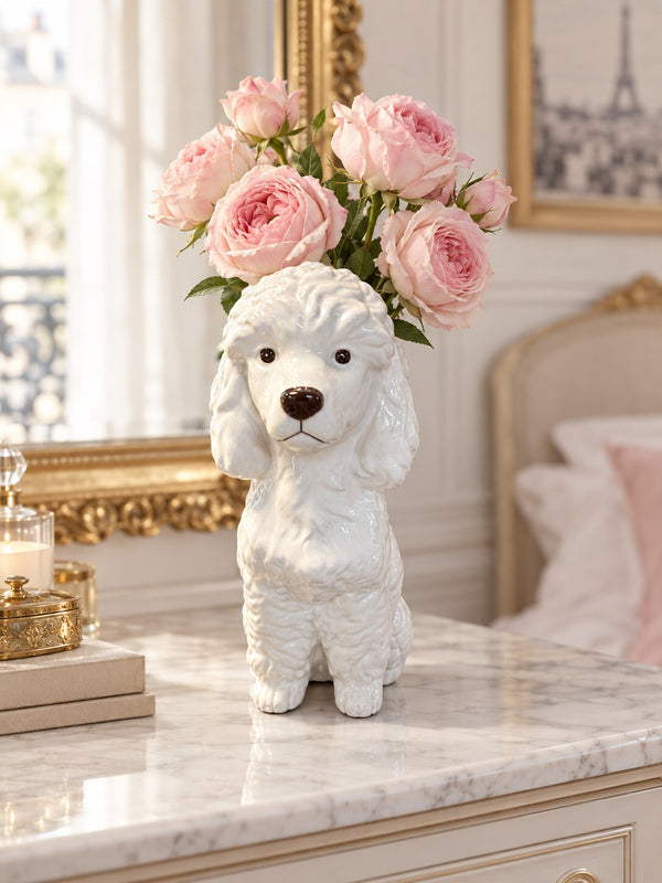 Caniche white poodle dog vase with pink garden roses on a marble dresser