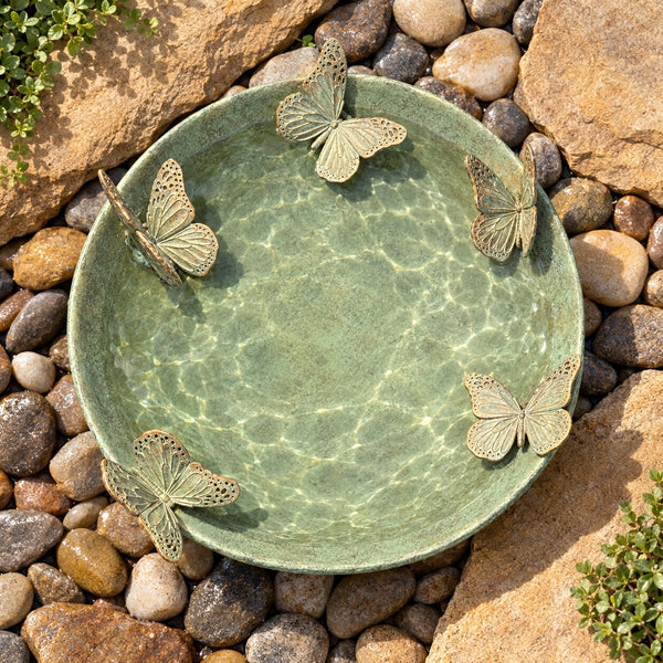 Mariposas verdigris bird bath with five butterflies viewed from above on river pebbles