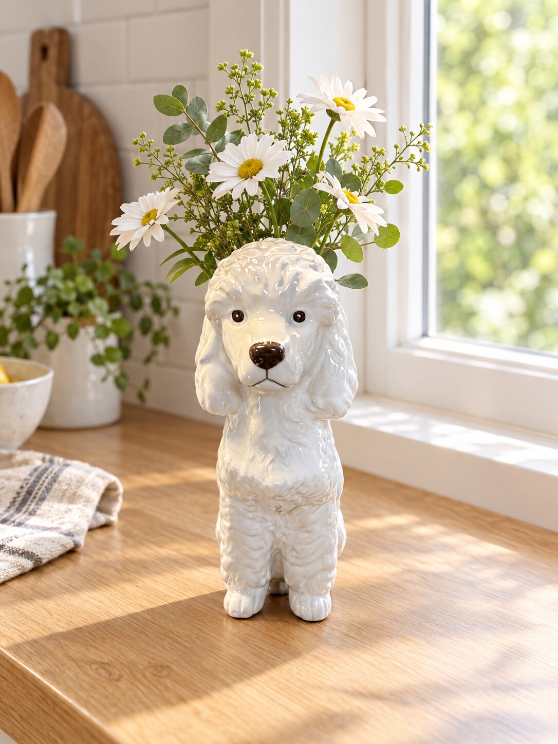 Caniche glossy white poodle vase with daisies on a kitchen bench