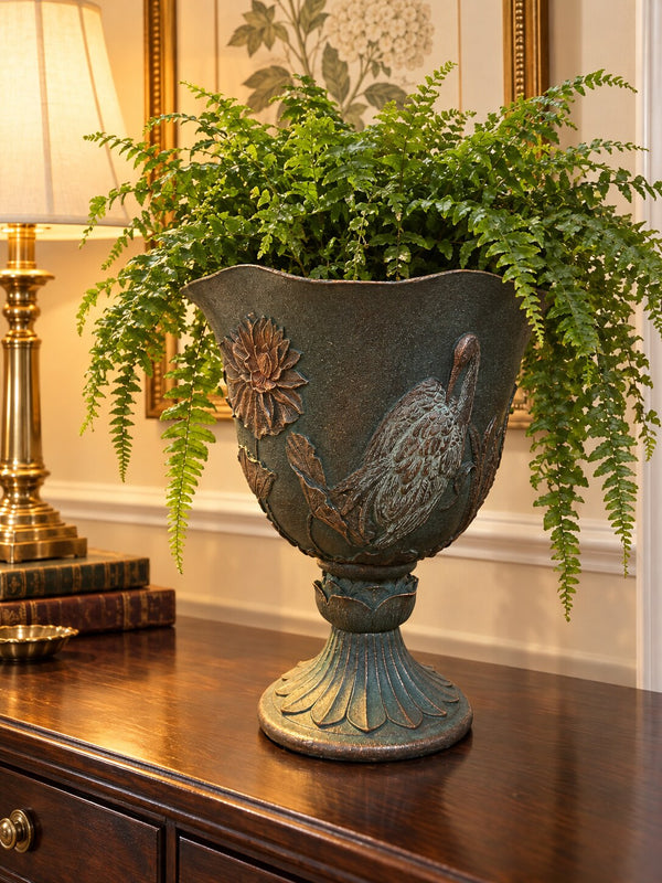 Casa tall footed resin planter with crane relief and Boston fern on a hallway console