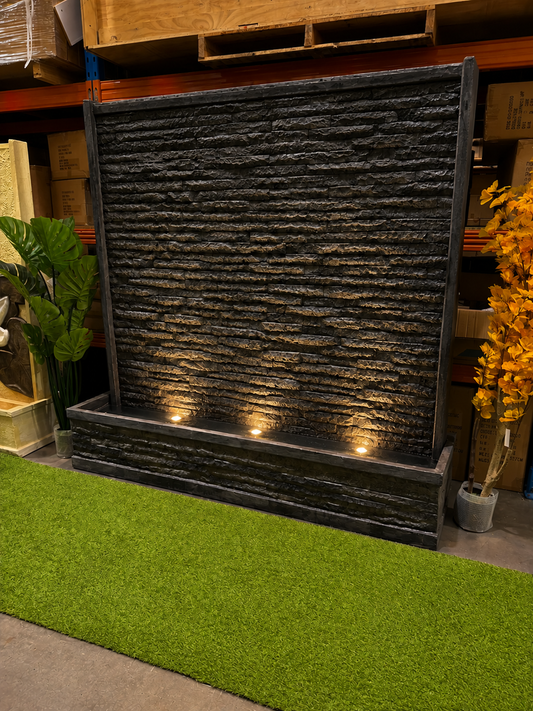 Eden granite look outdoor water wall with three warm base spotlights uplighting the stone curtain