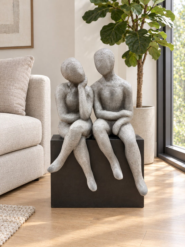 Gustaria two seated figures sculpture in grey and black in a modern living room
