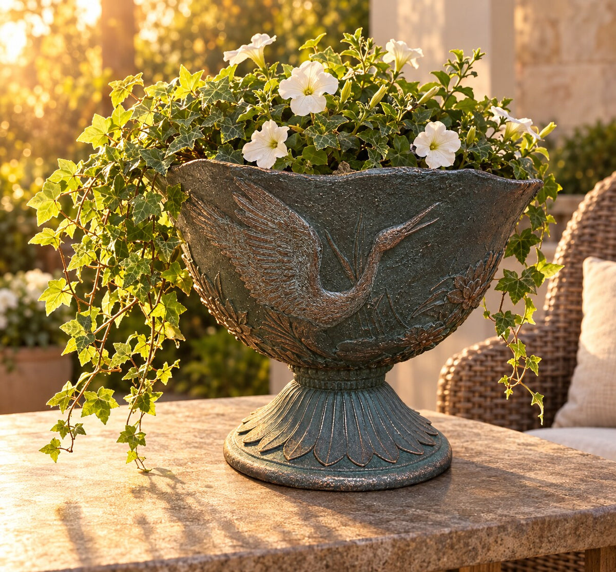 Hacienda crane urn planter with trailing ivy and petunias on a stone patio table