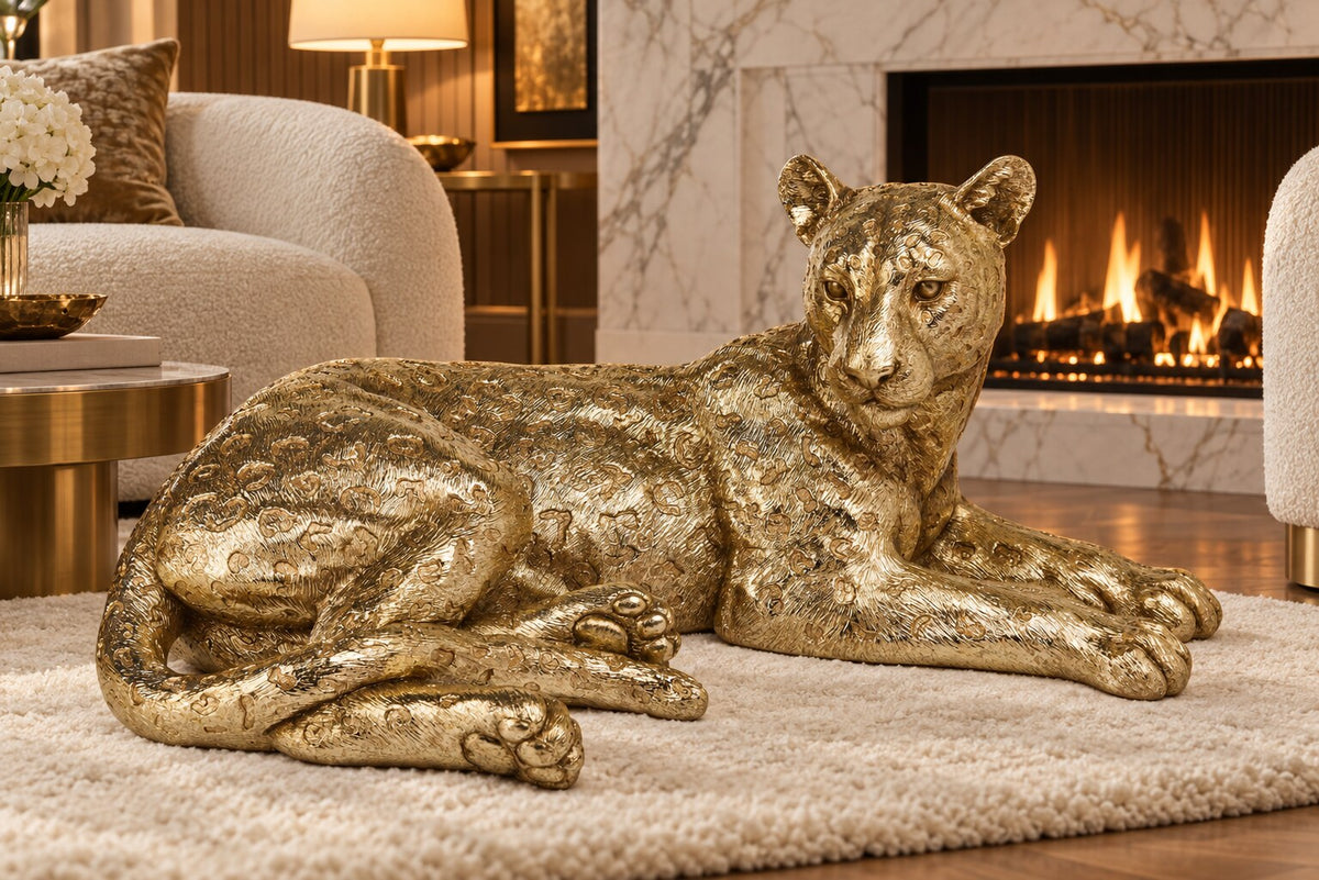 Leopardo gold lying leopard statue on a cream rug in front of a marble fireplace