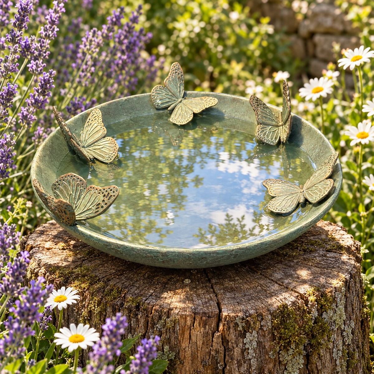 Mariposas butterfly bird bath on a tree stump in a cottage garden with lavender